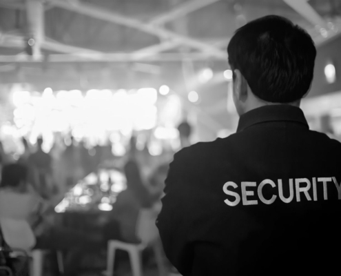 Security guard monitoring a crowd at a large indoor event to maintain crowd control and guest safety