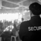 Security guard monitoring a crowd at a large indoor event to maintain crowd control and guest safety