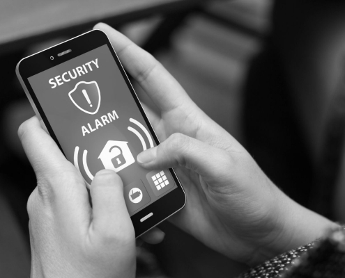 Person using mobile phone security app to manage alarm system and prevent false alarms