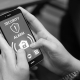 Person using mobile phone security app to manage alarm system and prevent false alarms