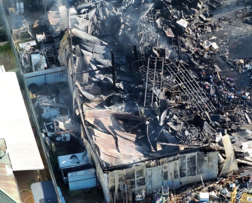 Close-up aerial image of fire-damaged buildings captured by PGC Aerial in The Rock, NSW.