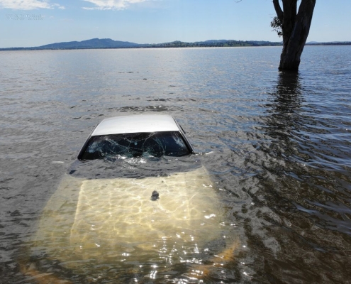Close-up PGC Aerial Gallery image of a car submerged in floodwater during an incident response.