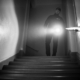 Security guard carrying out a mobile patrol inspection inside a building stairwell at night