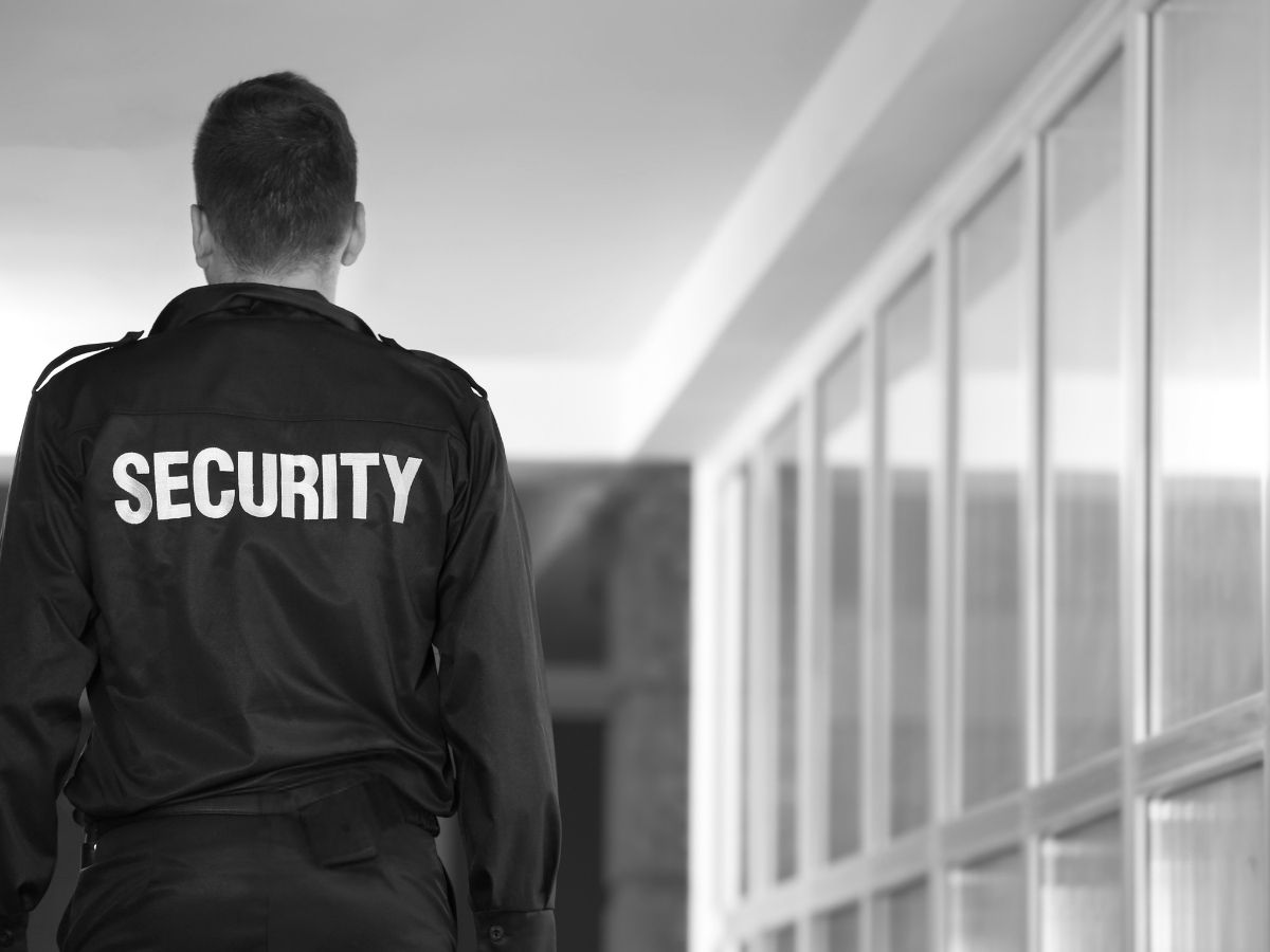 Security guard standing outside a commercial building during an after hours security patrol, monitoring and protecting business premises.